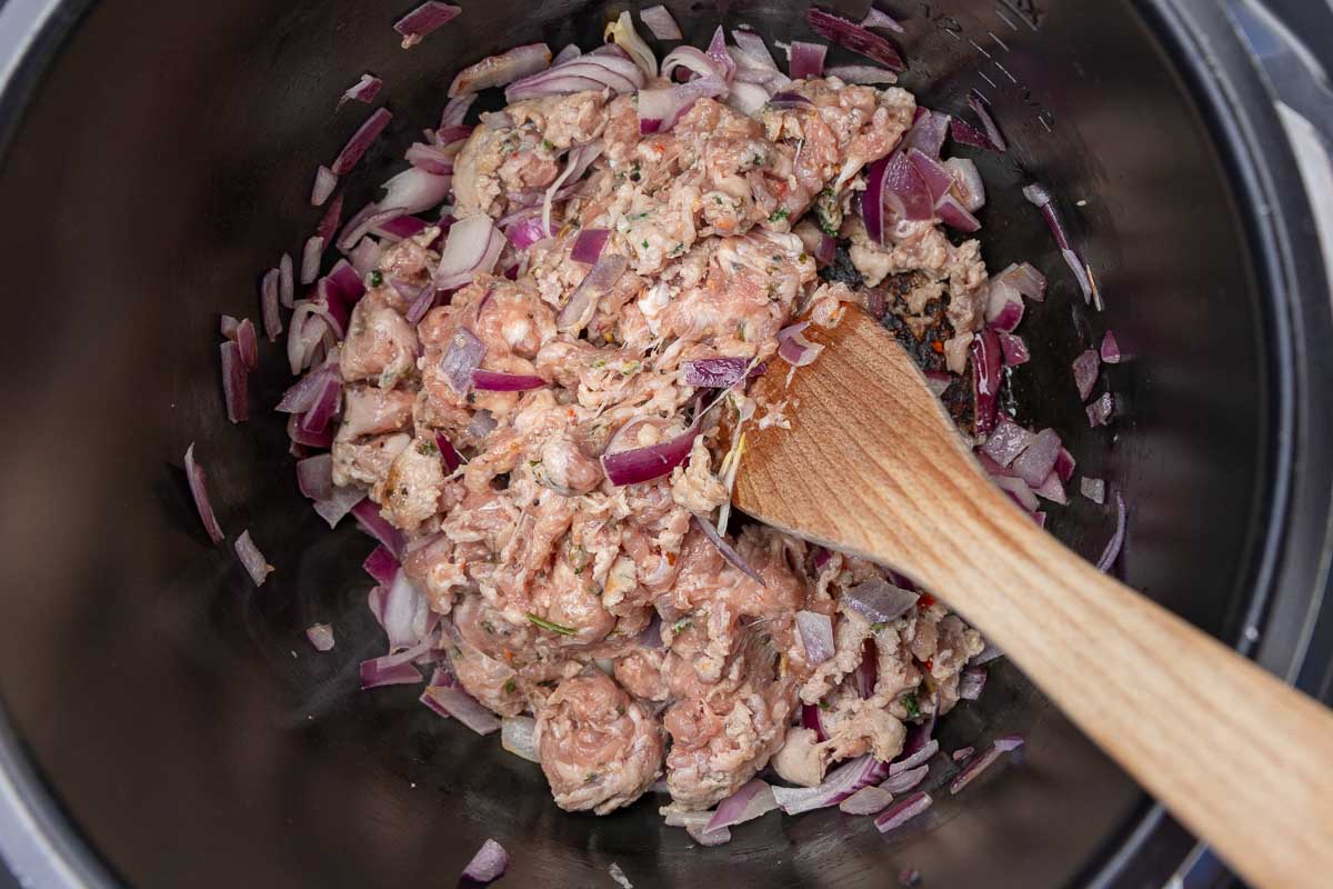 Browning Italian sausage and chopped onions in a crockpot.