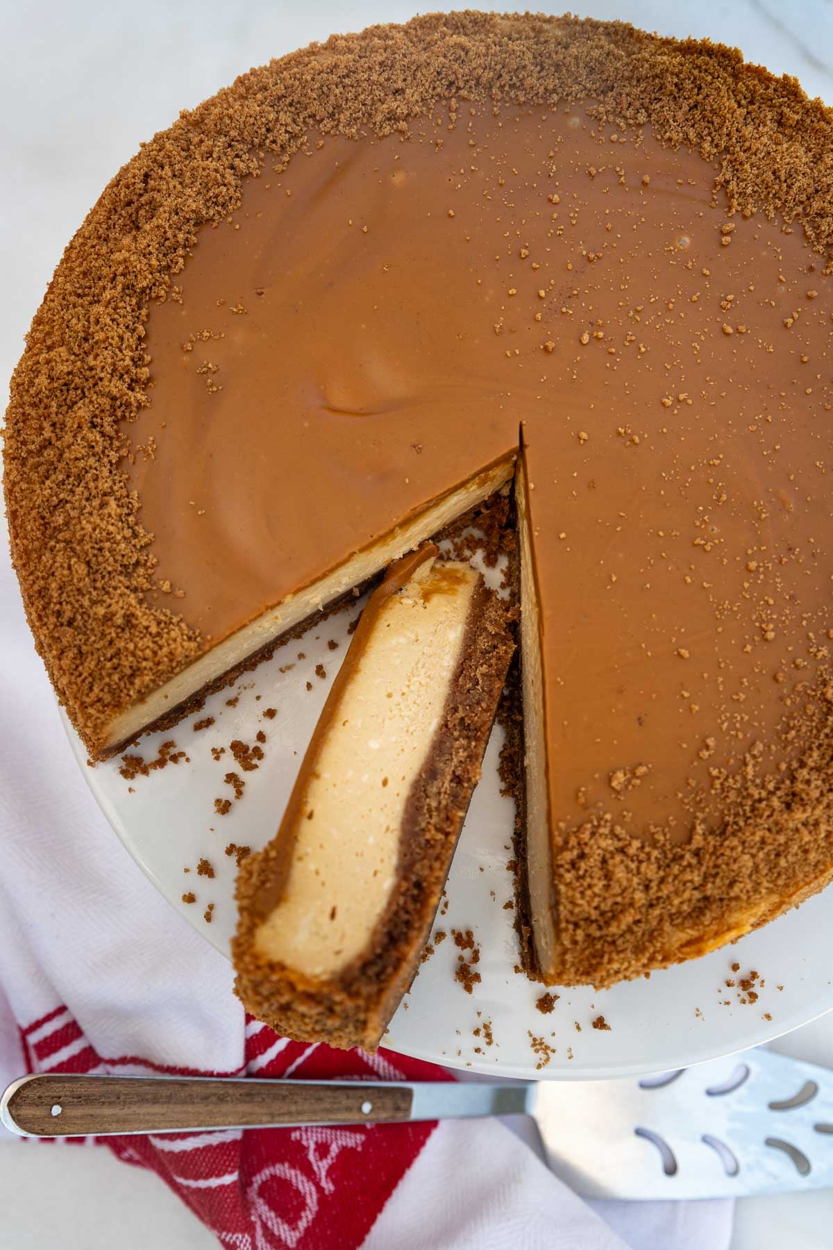 The cheesecake photographed from above with a piece cut out of it and laid on its side, with a cake slice next to it.
