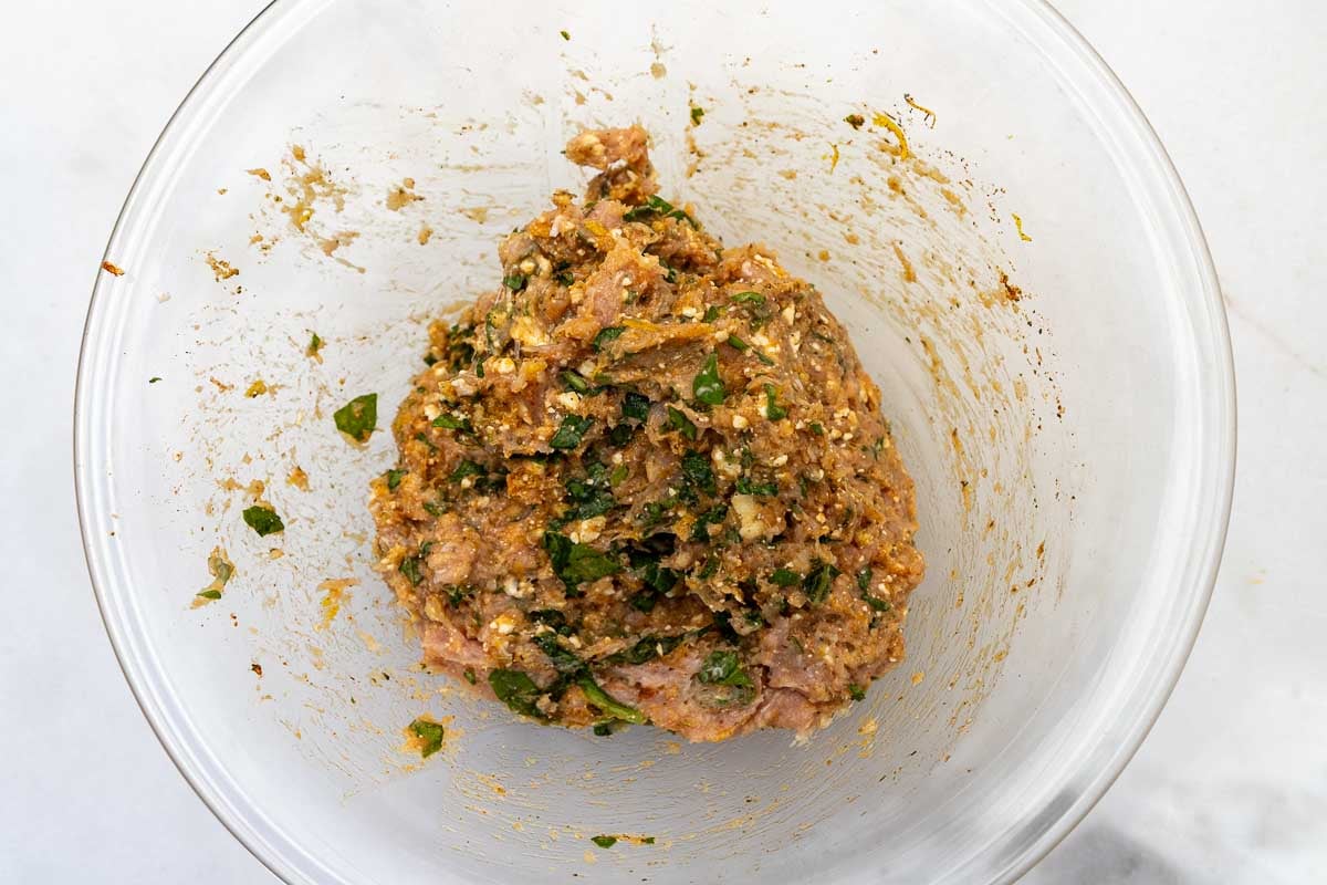 Chicken patty mixture in a clear bowl, ready to be shaped into burgers.