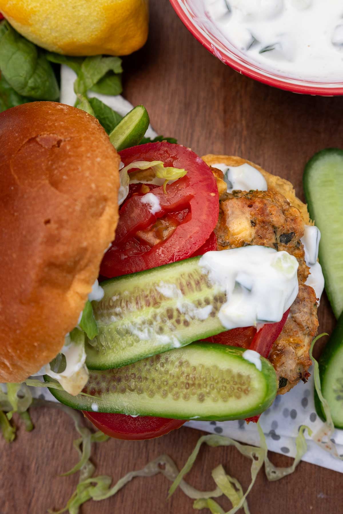 Overhead and closeup view of one of the burgers with the top of the bun half removed and the inside of the burger visible.
