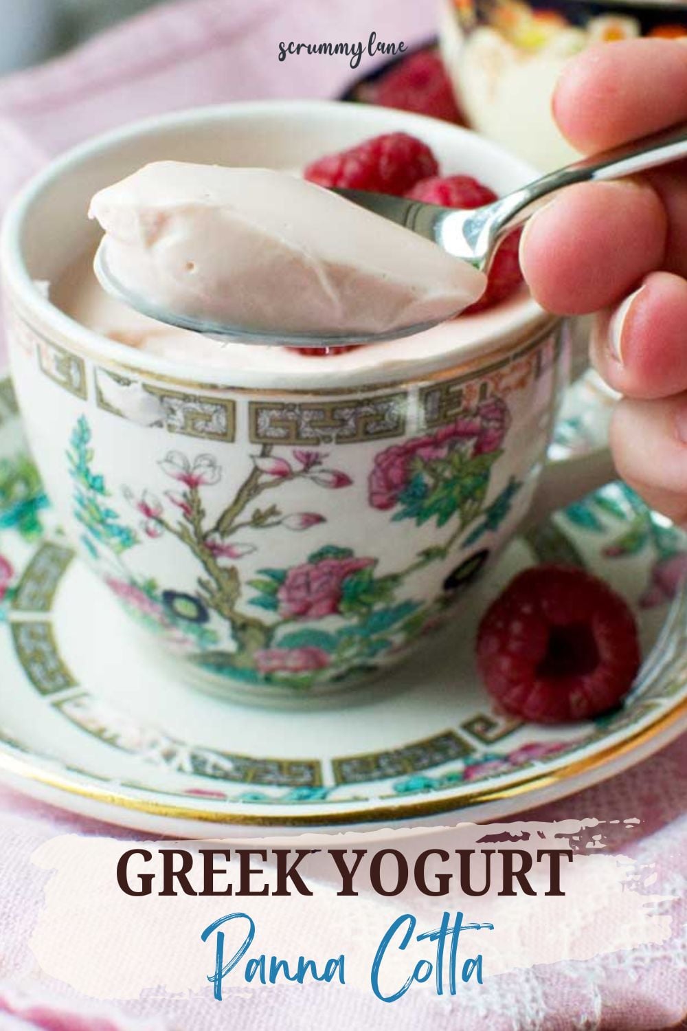 A closeup of someone scooping Greek yogurt panna cotta with a spoon, with a light pink background and a title for Pinterest.