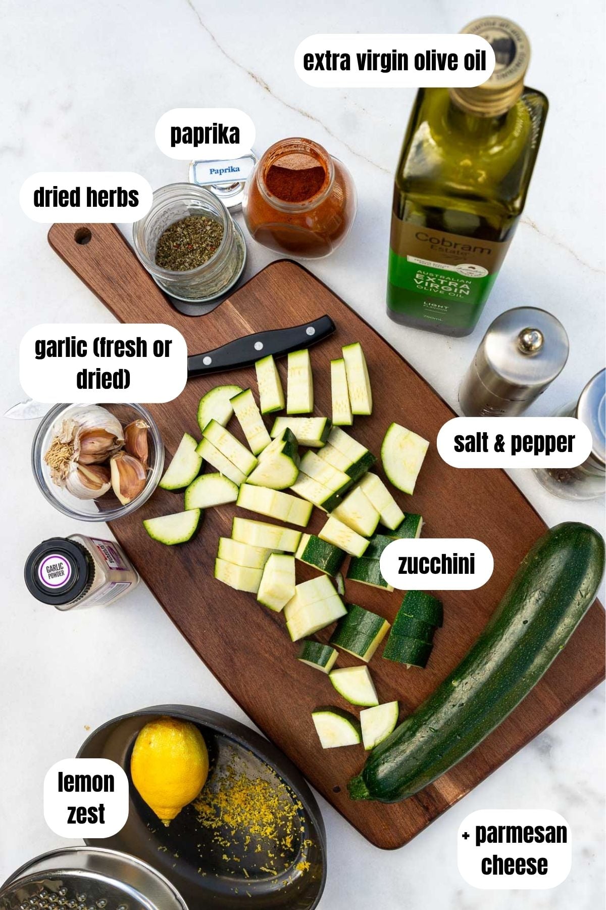 All the ingredients needed to make sauteed zucchini, labelled, including zucchini, lemon zest, paprika, garlic, olive oil, dried herbs, salt and pepper, and parmesan cheese.