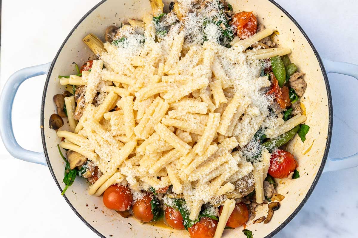Overhead view of the ingredients for the pasta in a big cast iron pan, ready to be stirred.