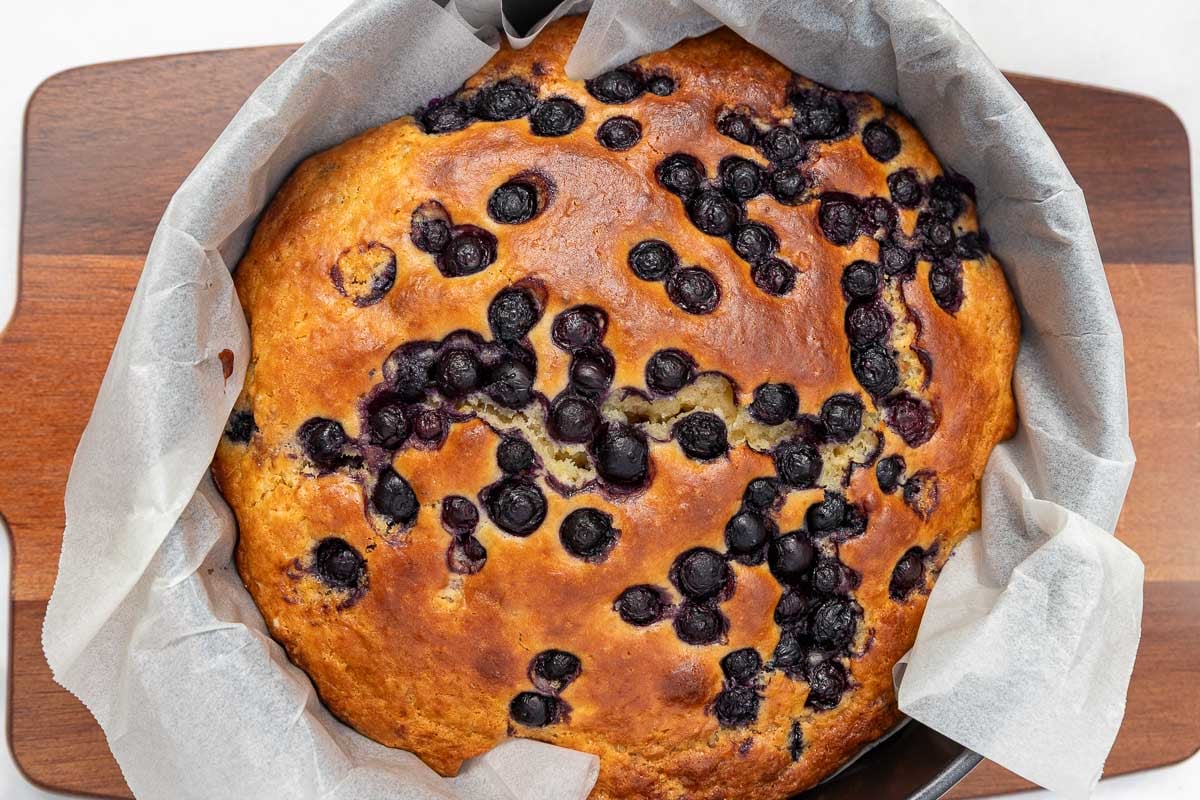 Overhead view of the cake just out of the oven in its lined baking pan.